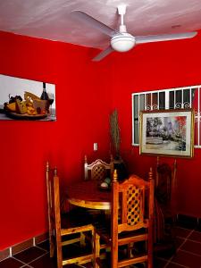 a red dining room with a table and a ceiling fan at Departamentos “Ama” in Puerto Vallarta