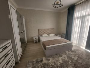 a bedroom with a bed and a large window at Hilmar in Tashkent