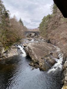 a river with a bridge in the middle of it at Cameron apartment Loch Ness in Fort Augustus