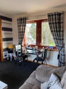 a living room with a table and a couch at Cameron apartment Loch Ness in Fort Augustus