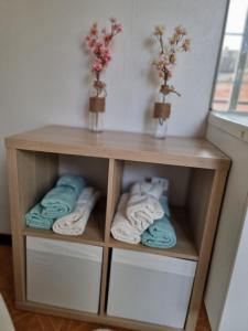 ein kleines Holzregal mit Handtüchern in einem Zimmer in der Unterkunft L Essentiel Appartement accueillant 5 pers 