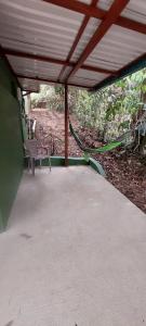 acovered porch with a bench and a hammock at Corcovado & Drake Inn in Drake