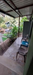 zwei Stühle auf einer Terrasse unter einem Dach in der Unterkunft Corcovado & Drake Inn in Drake