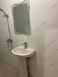 مسكن الجنان للوحدات السكنية في المدينة المنورة: حمام مع حوض ومرآة على الحائط