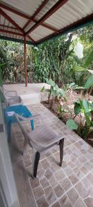 eine Bank und ein Stuhl auf einer Terrasse in der Unterkunft Corcovado & Drake Inn in Drake