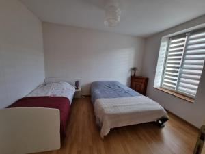 1 Schlafzimmer mit 2 Betten und einem Fenster in der Unterkunft L Essentiel Appartement accueillant 5 pers 