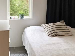 1 dormitorio con cama con almohada y ventana en Holiday home NYKÖPING II en Nyköping