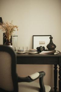 une table avec des assiettes, un miroir et une chaise dans l'établissement La Maison des Dames, 