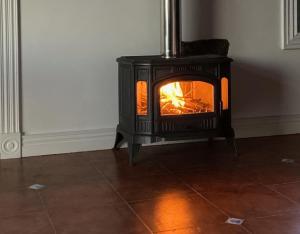 a woodburning stove in the corner of a room at La VIGIE de CASTELROCK ( Casa Petunia ) in Mosteiros