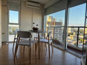 a dining room with a table and chairs and a large window at Cuyen 1 Pleno Centro in Santa Rosa