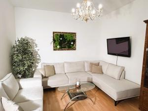 a living room with a white couch and a chandelier at Luxusný apartmán v centre mesta in Piešťany