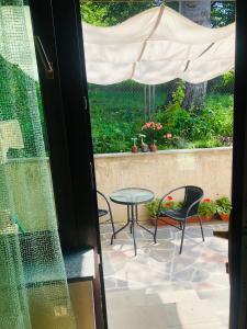 a patio with a table and chairs and an umbrella at Fortuna Cottage Bakuriani in Bakuriani