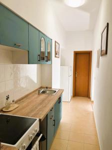 a kitchen with blue cabinets and a sink at Luxusný apartmán v centre mesta in Piešťany