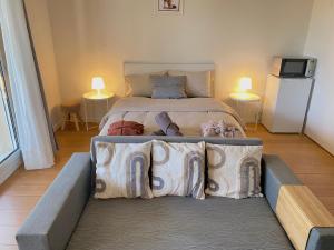 una camera da letto con un letto con cuscini sopra di Cozy Riverfront Living, 5-Min Walk To Riverside Train a Neuilly-Plaisance