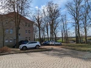 três carros estacionados num parque de estacionamento ao lado de um edifício em Suite 13 im Wald mit Balkon em Amberg