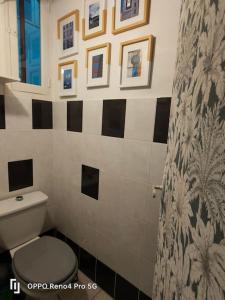 ein Badezimmer mit WC und Bildern an der Wand in der Unterkunft Grand T2 esprit loft Cœur de Ville in Sète