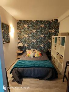 Schlafzimmer mit einem Bett mit Blumentapete in der Unterkunft Grand T2 esprit loft Cœur de Ville in Sète