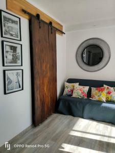 ein Wohnzimmer mit einem blauen Sofa und einem Spiegel in der Unterkunft Grand T2 esprit loft Cœur de Ville in Sète