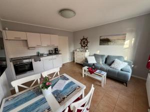 a kitchen and a living room with a couch and a table at Wohlfuehl-Orte24 am Hafen in Schaprode, Rügen in Schaprode