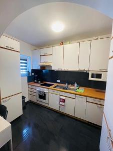 a kitchen with white cabinets and a sink at Hotel Shelby Apartments in Garbsen