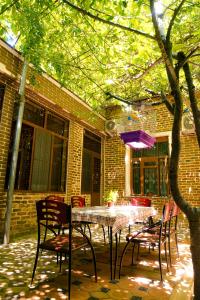 a patio with a table and chairs in front of a building at Old Radio hostel in Samarkand