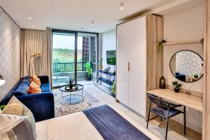 uma sala de estar com um sofá azul e uma mesa em Zimbali Lakes Resort, Boulevard Suite, Ballito em Ballito