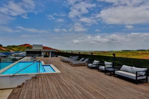 una terraza con tumbonas junto a una piscina en Zimbali Lakes Resort, Boulevard Suite, Ballito en Ballito