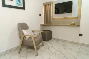 een kamer met een stoel en een tv aan de muur bij Hotel Santa Fe in Puerto Ayora