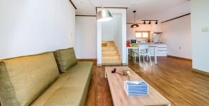 a living room with a couch and a table at Boreum Pension in Seogwipo