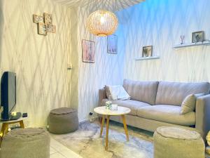 a living room with a couch and a table at Cocon chaleureux entièrement renové à 150m de le Seine in Saint-Mammès