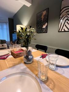 a dining room table with plates and glasses on it at Kings Bridge Townhouse in Belfast