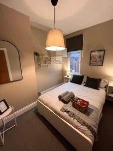 a bedroom with a bed with a basket on it at Kings Bridge Townhouse in Belfast