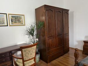 un gran armario de madera en una habitación con silla en Bonvenon2Volme Apt&Room, en Pula