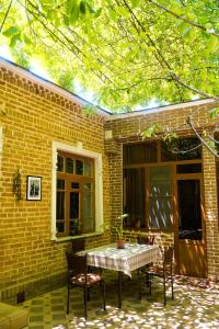 a patio with a table and chairs in front of a brick building at Old Radio hostel in Samarkand