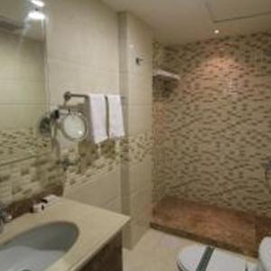 a bathroom with a sink and a toilet and a shower at بنان فال للشقق المخدومة in Hafr Al Baten
