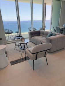 a living room with a couch and a view of the ocean at Ayia Napa Marina Exclusive Apartment in Ayia Napa