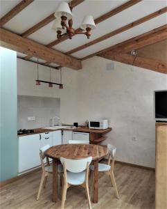 cocina y comedor con mesa de madera y sillas en Casa do Lecer, en La Teijeira