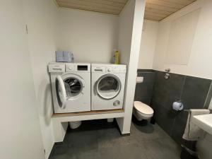 a bathroom with a washing machine and a toilet at Diner/Wallenhorst in Wallenhorst