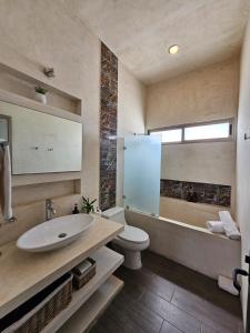 a bathroom with a sink and a tub and a toilet at Casa Américas in Mérida