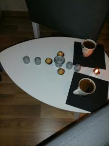 una mesa blanca con una taza de café y galletas en Mima studio en Kragujevac