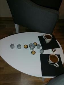 - une table blanche avec une tasse de café et des beignets dans l'établissement Mima studio, à Kragujevac