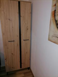 un armario de madera sentado junto a una pared en Mima studio en Kragujevac