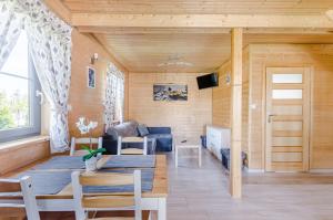 a living room with a blue couch and a table at Domki letniskowe Agata in Jantar