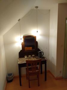 a room with a table with a tv and a chair at Escale Élégante à Héricourt in Héricourt