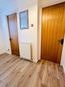 an empty room with a wooden door and wooden floors at *Newcastle City* Modern Flat With FREE Parking in Newcastle upon Tyne