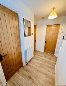 a hallway with a wooden door and wooden floors at *Newcastle City* Modern Flat With FREE Parking in Newcastle upon Tyne