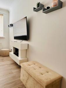 a living room with a couch and a tv on a wall at *Newcastle City* Modern Flat With FREE Parking in Newcastle upon Tyne