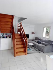 a living room with a staircase and a couch at Agréable pavillon in Nailloux