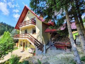 a house with a balcony and a bench in front at Zawoja 1895 sauna bania in Zawoja