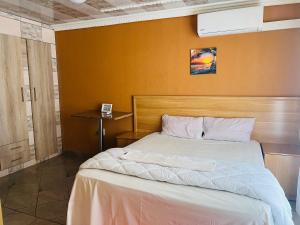 una camera con un letto e una parete gialla di The journey guest house a Mzinti